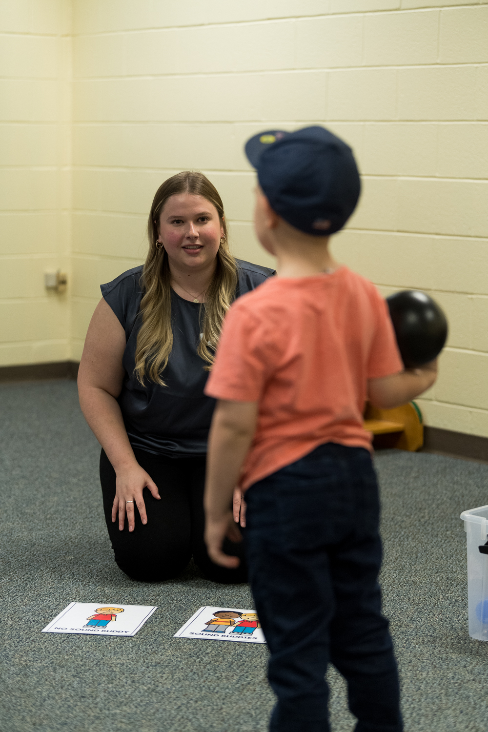 a student smiling and working with a small child