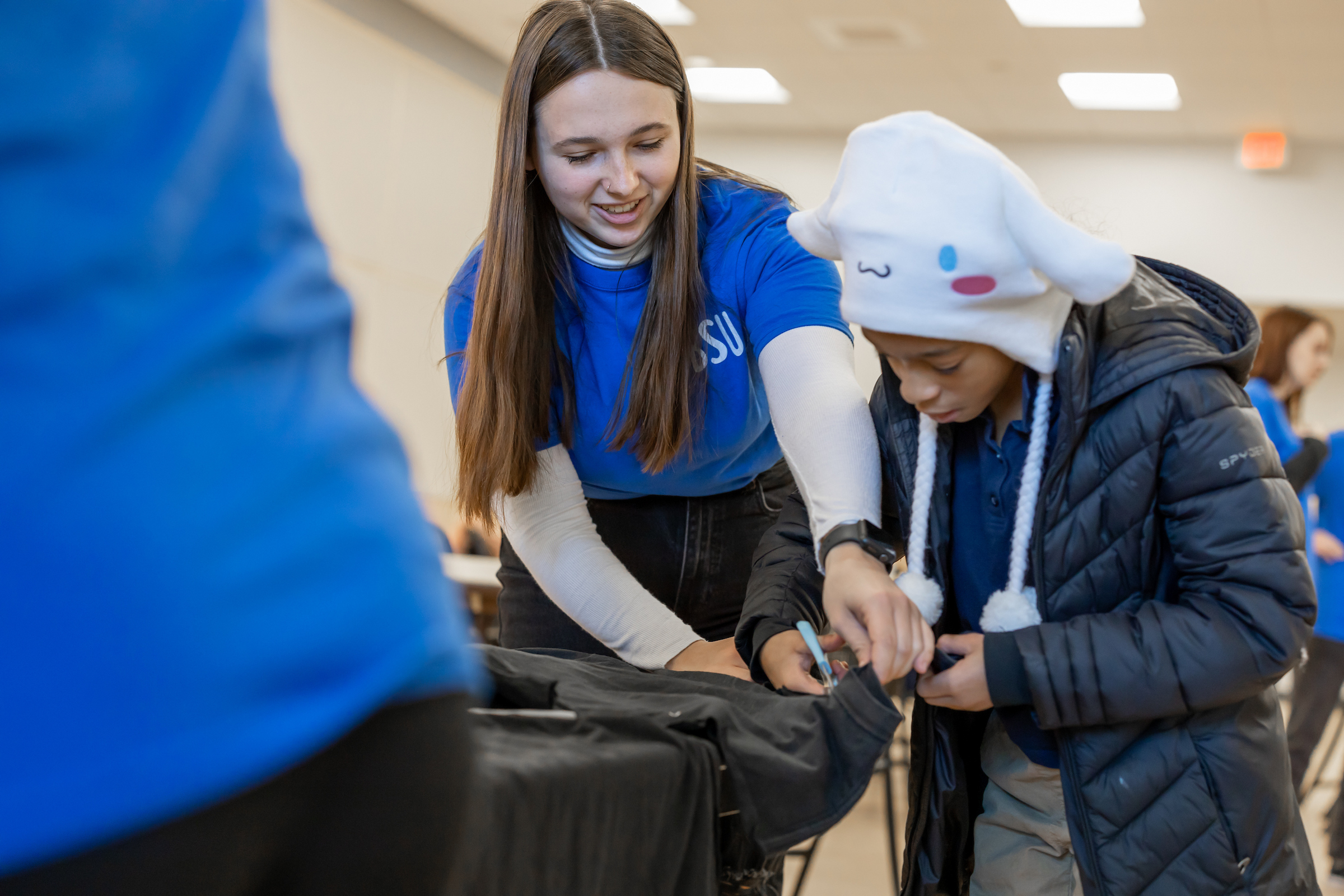 a BSU student helps an elementary students with a Universal Children's Day project