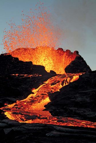 The top of an active volcano with hot lava spraying up from it and a river of hot lava flowing down it