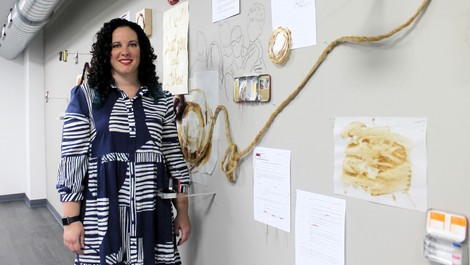 Megan Kenealy stands next to her artwork.