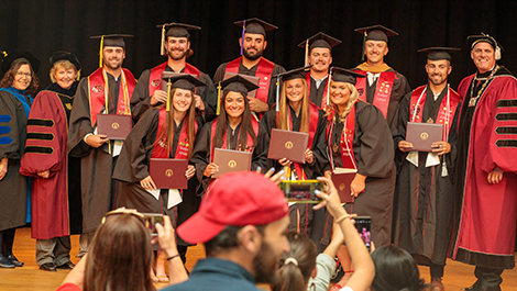 Graduates pose for a photo with BSU administrators and faculty.