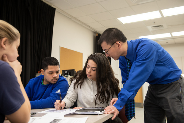 Dr. Tom Wu working with students in a kinesiology class