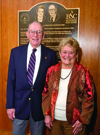 Frank and Dorothy Dunn standing in front of a plaque dedicating the conference suite to them.