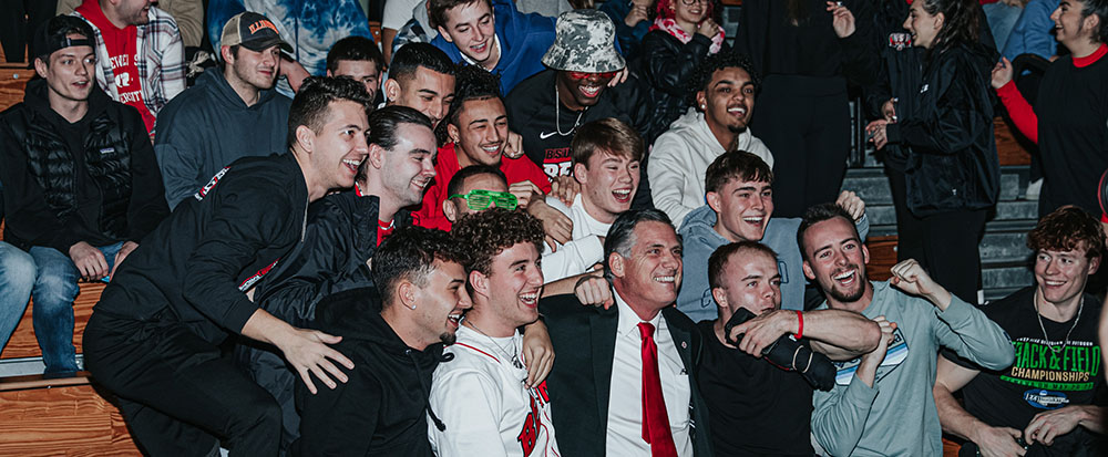 BSU president Fred Clark smiling with a crowd of students at Midnight Madness