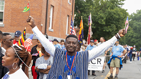 A Mandela fellow holds two flags high in the air