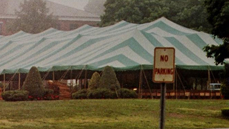 A green and white graduation tent on the quad