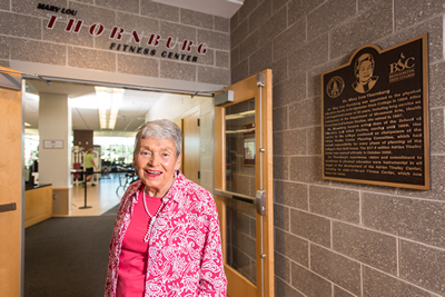 Mary Lou Thornburg poses for a photo in front of the fitness center named for her.