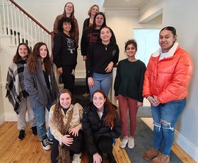 12 Justice Fellows posing on the stairs inside the new MRISJ building