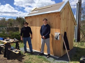 Two students in front of the shed