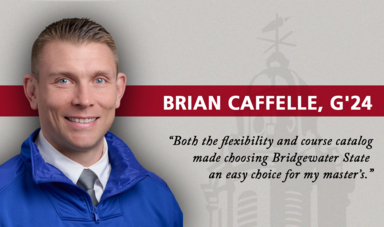 A man smiles and looks at the camera wearing a blue jacket