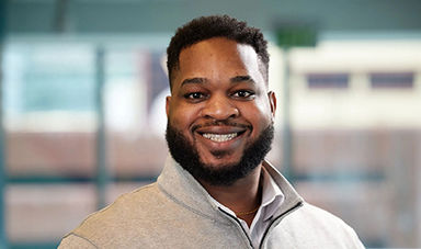 Headshot of Joseph Defendre standing in front of windows