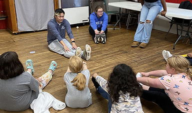 BSU students teach a stretching exercise to girls
