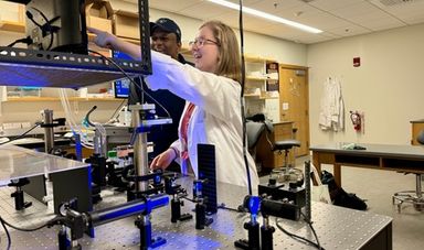 Helena works with optical tweezers in a lab alongside her professor.
