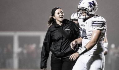 Kat Sevigny talks to a football player