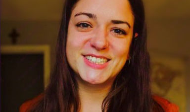 A woman smiles looking into the camera