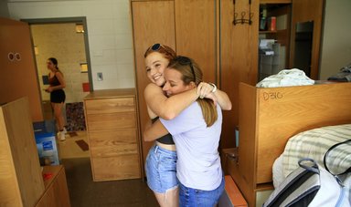 Two friends embrace in their new dorm room