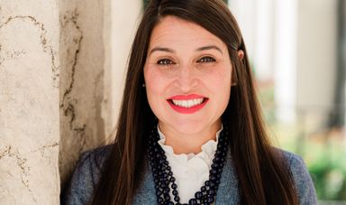 Woman with brown hair smiles at camera