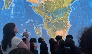 Students and an instructor gaze up at the EarthView globe.