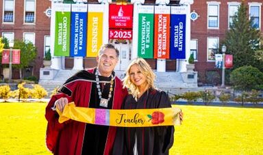 Haley March and President Clark pose for a photo in front of Boyden Hall.