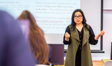 Dr. Hannarae Lee teaching Analyzing Criminal Justice Data class in front of a projector screen