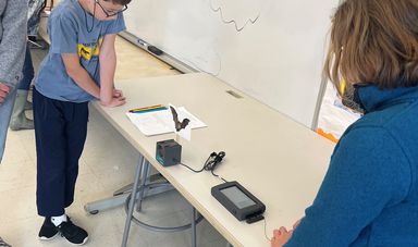 Two students conducting an experiment with scientific instruments on a table