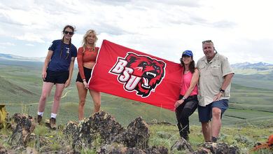 BSU Students and their faculty mentor holding a red BSU flag in Montana
