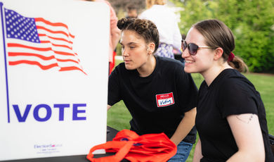 Two students registering to vote at a campus registration drive.
