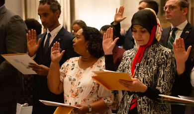 The twenty five inductees to citizenship listen to the speakers before taking the oath of citizenship during the Constitution Day naturalization ceremony in the National Archives Rotunda on Sept. 15, 2023.