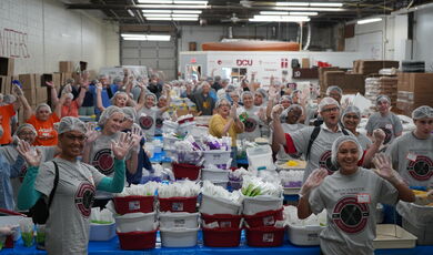 A group of people put together boxes of food 