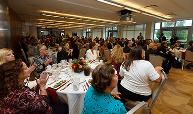 Dunn Conference Suite with people eating a meal at round tables.