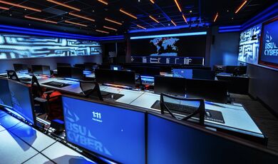 The inside of the cyber range with numerous computer monitors and a large wall-mounted display.