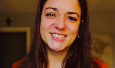 A woman smiles looking into the camera 
