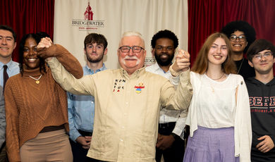 Students pose for a group photo and hold hands with President Walesa.