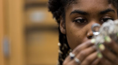 A student inspects a rock with a magnifying glass