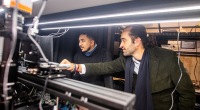 Dr. Otalvaro working in the photonics lab with a student