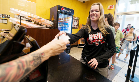 A student pays for a Dunkin order with her Connect Card