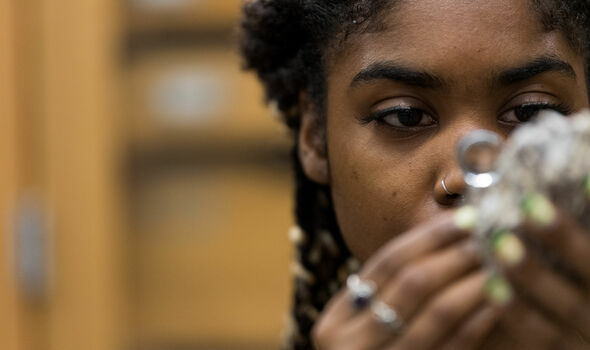A student inspects a rock with a magnifying glass