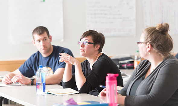 3 students in an education class, one speaking and the others listening