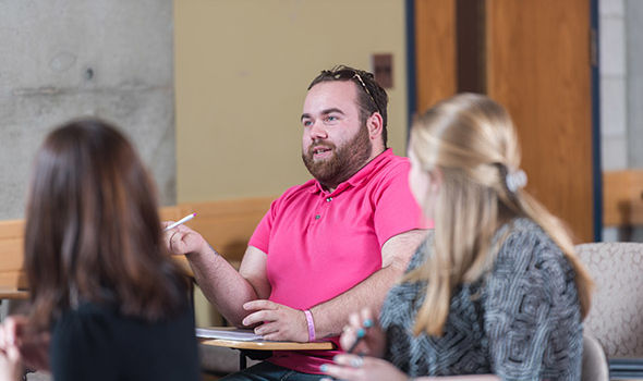 a BSU Counselor Ed student speaks in class while 2 others listen