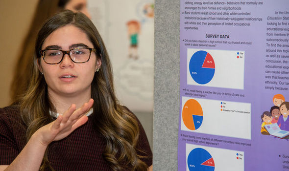 a female student giving a poster presentation on her research