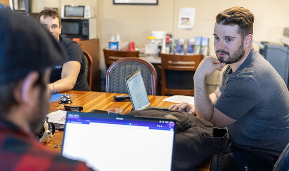 BSU students sitting around a table in the Military and Veterans Services office talking with their laptops open