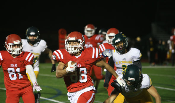 A BSU football player running with the football during the homecoming game
