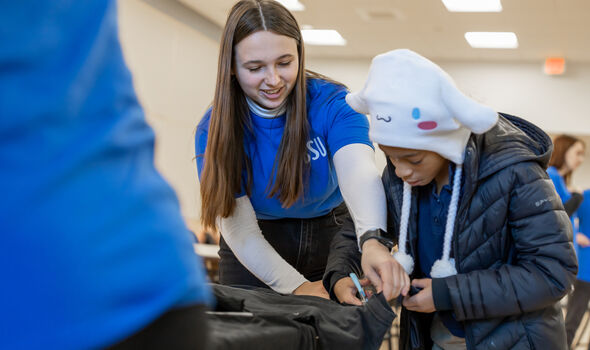 a BSU student helps an elementary students with a Universal Children's Day project