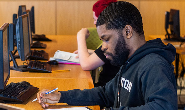 A political science student taking notes in class