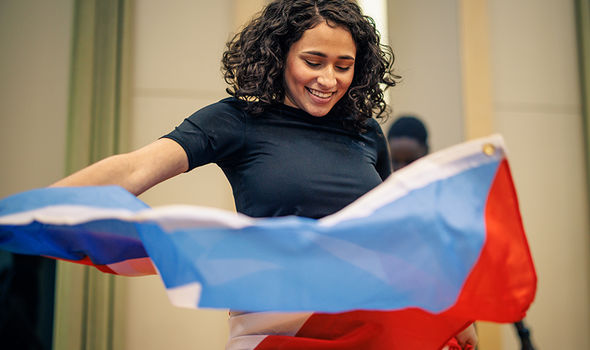 A student dances with the Puerto Rican flag at a Black History Month celebration
