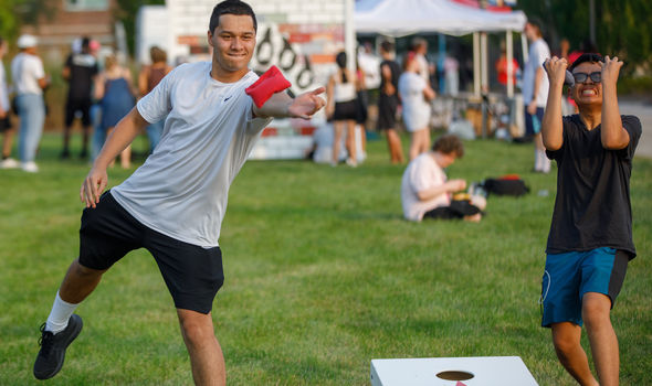 Welcome Back BBQ with students in foreground playing cornhole