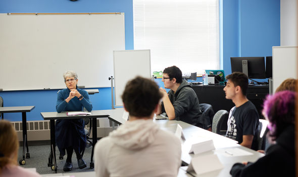 Dr. Susan Eliason teaches an Elementary Education class. She and the students sit at desks set up in a hollow square.