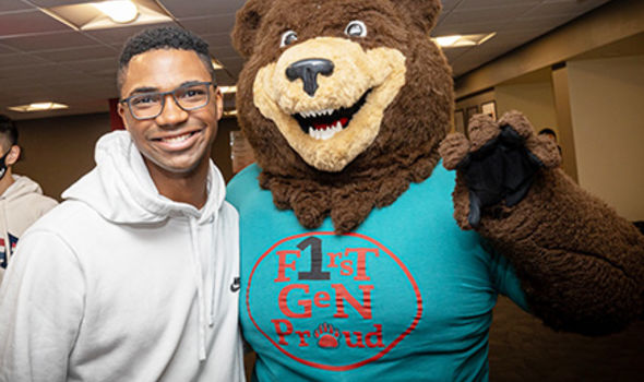 A student poses with Bristaco, BSU's Bear mascot, who wears a First Gen Proud shirt