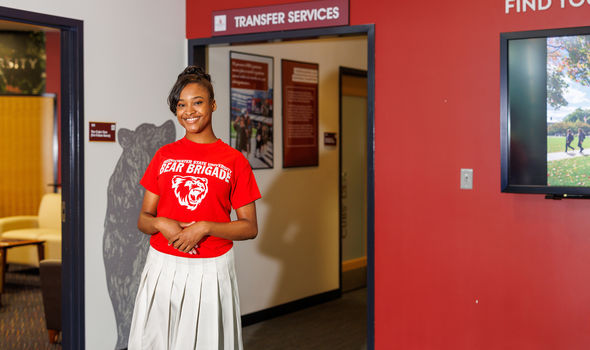 BSU transfer student smiling and walking out of the Transfer Services Office
