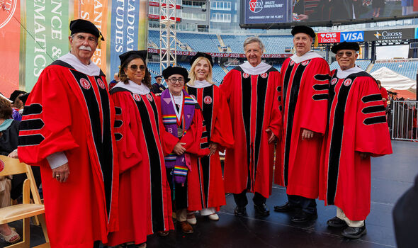 A group photo of 7 members of the Board of Trustees at 2025 Commencement